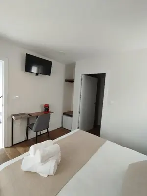 a bedroom with a bed with a chair and a desk at Pension Silvent in Ribadeo