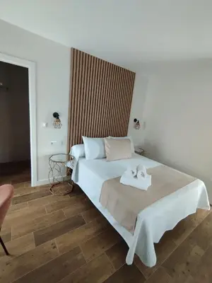 a bedroom with a bed with two towels on it at Pension Silvent in Ribadeo