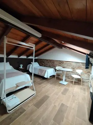 a bedroom with two bunk beds and a table at Pension Silvent in Ribadeo