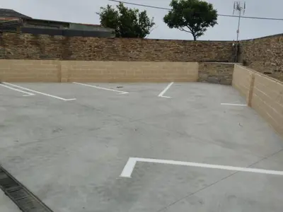 an empty parking lot with a brick wall at Pension Silvent in Ribadeo