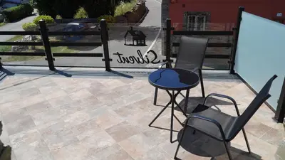 a patio with a table and chairs and a fence at Pension Silvent in Ribadeo
