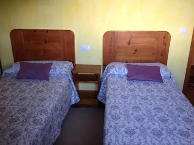two beds sitting next to each other in a room at El Mirador de los Trobos in Villar de Otero