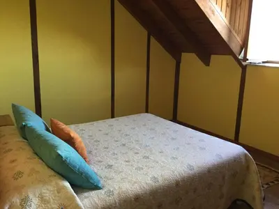 a bedroom with a bed with blue pillows on it at El Mirador de los Trobos in Villar de Otero