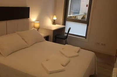 a bedroom with a white bed with two towels on it at Alojamiento Doble R in Villalba