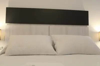 a bed with two white pillows on top of it at Alojamiento Doble R in Villalba