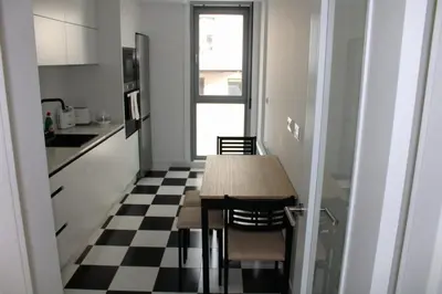 a kitchen with a table and a black and white checkered floor at Alojamiento Doble R in Villalba