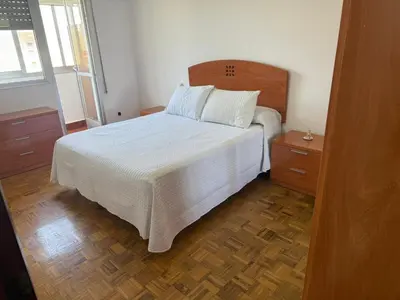 a bedroom with a white bed and two night stands at Apto Mirandés in Burela de Cabo
