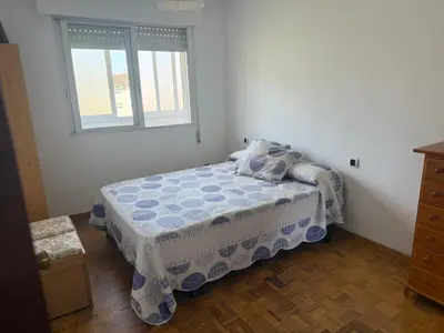 a small bedroom with a bed and a window at Apto Mirandés in Burela de Cabo