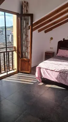 a bedroom with a bed and a large window at Casa Loma Manolo in Molinaseca