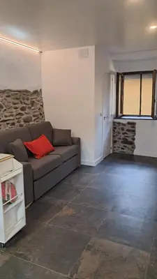 a living room with a couch and a stone wall at Casa Loma Manolo in Molinaseca
