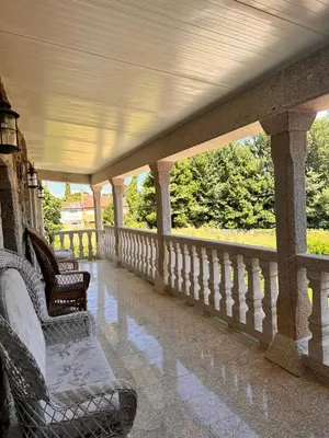 a covered porch with two chairs and a porch at Casa do Cabo - 3 habitaciones con 3 baños independientes