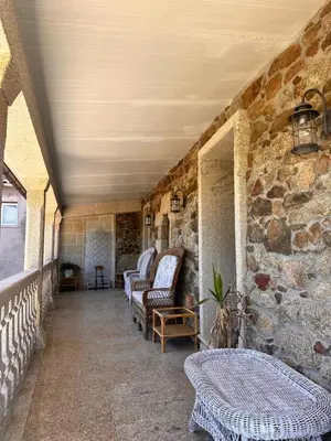a room with chairs and a stone wall at Casa do Cabo - 3 habitaciones con 3 baños independientes