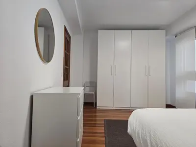 a white bedroom with a white dresser and a mirror at Apartamento Lugo centro muralla in Lugo
