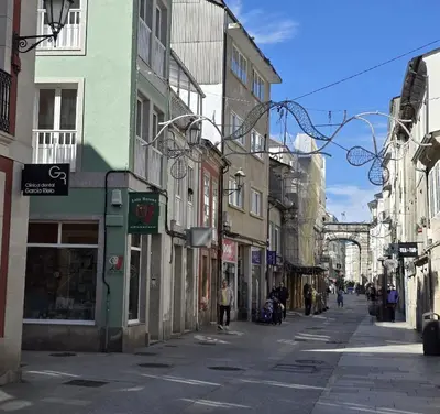 an empty city street with people walking down the street at Apartamento Lugo centro muralla in Lugo