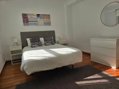 a bedroom with a bed with a dresser and a mirror at Apartamento Lugo centro muralla in Lugo