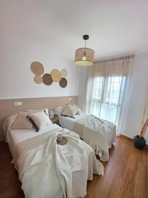 two beds in a room with hats on the wall at Costa Foz Apartment Playa de Llas, terraza, piscina y pista de pádel in Foz