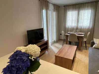 a living room with a television and a table with flowers at As Tres Praias in Burela de Cabo