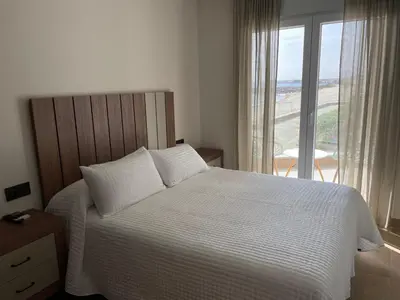 a bedroom with a bed and a large window at As Tres Praias in Burela de Cabo