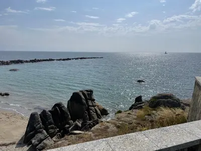 a view of the ocean with rocks on the beach at As Tres Praias in Burela de Cabo