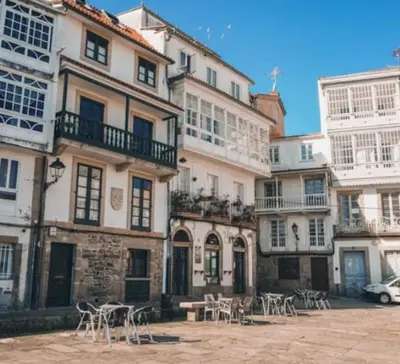 a group of buildings with tables and chairs in front of them at Adiva Casa Da Avoa in Puentedeume