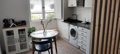 a small kitchen with a table and a washing machine at Adiva Loft in Puentedeume