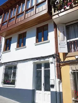 a white building with a white door and windows at Adiva Loft in Puentedeume