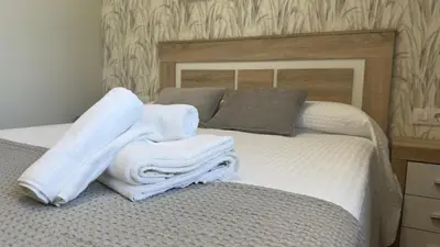 a bedroom with a bed with towels on it at Carude 76 in Monforte de Lemos