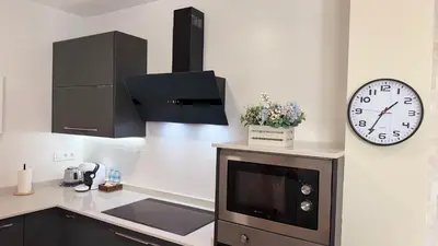 a kitchen with a sink and a clock on the wall at Carude 76 in Monforte de Lemos