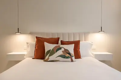 a bedroom with a white bed with orange pillows at Loft América 41 B in Melide