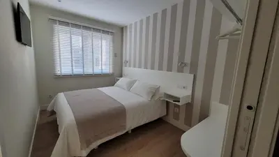 a bedroom with a white bed and a window at Egeria Casa Jardín in Caldas de Reis