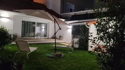 a patio with an umbrella in the yard of a house at Egeria Casa Jardín in Caldas de Reis