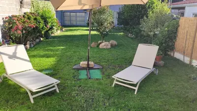 two chairs and an umbrella in a yard at Egeria Casa Jardín in Caldas de Reis