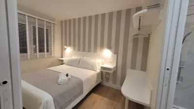 a bedroom with a bed with a cat sitting on it at Egeria Casa Jardín in Caldas de Reis