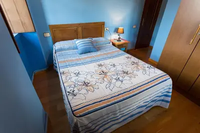 a bedroom with a bed with a blue wall at Casa Aniceto in Taramundi