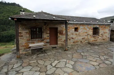 a brick building with a bench in front of it at Casa Aniceto in Taramundi