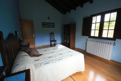 a bedroom with a large white bed in a room at Casa Aniceto in Taramundi