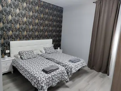 a bedroom with a bed with a red wall and two night stands at Vivienda Turística Mou in Arzúa