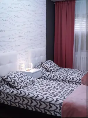 a bedroom with a bed and a white wall at Vivienda Turística Mou in Arzúa