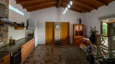 a kitchen with wooden cabinets and a clock on the wall at Casa Barxelo con piscina en Monforte de Lemos in Monforte de Lemos
