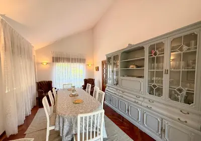 a dining room with a table and a china cabinet at Casa Carlés by URent in Puentecesures