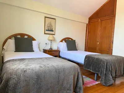 a bedroom with two beds and a dresser at Casa Carlés by URent in Puentecesures