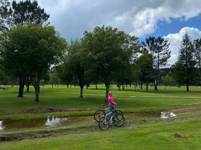 a woman riding a bike in a park at Casa Carlés by URent in Puentecesures