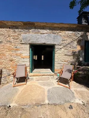 two chairs sitting in front of a stone building at Casa Albaredo, Aldea Rural, Boutique Hotel, Retreat, in O Cebreiro