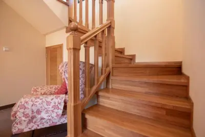 a wooden staircase with a chair and wooden floors at Gavian House in A Coruña