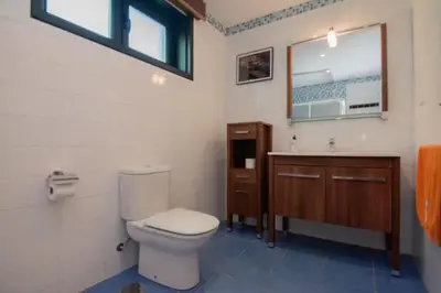 a bathroom with a toilet and a sink and a window at Gavian House in A Coruña