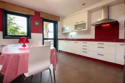 a kitchen with a table and a red and white kitchen at Gavian House in A Coruña