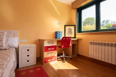 a bedroom with a desk and a red chair at Gavian House in A Coruña