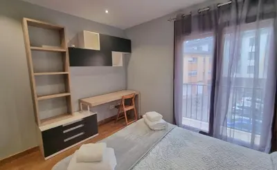 a bedroom with a desk and a bed with a window at A Casa de Chefa in San Ciprián