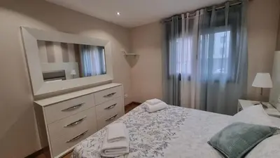 a bedroom with a bed and a dresser with a television at A Casa de Chefa in San Ciprián