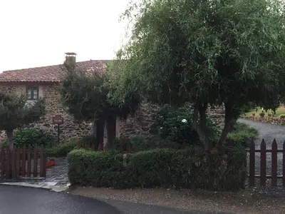 a stone house with a fence and a tree at Casa Torres in Cruces